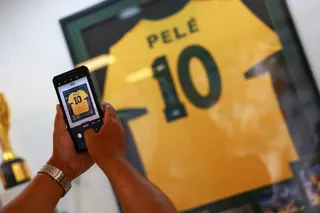 A visitor takes a picture of the Pele’s jersey on display. — Reuters pic