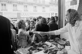 Bernadette Chirac shakes the hand of a woman in a market stall