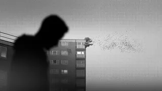 A sparse black and white image showing a silhouetted character with head drooped while a grotty block of council flats behind him grows a huge mushroom spore on its corner.