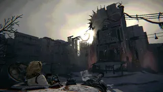 A view from a tank's turret of a ruined World War 2 era city illuminated by a sickly winter sun.