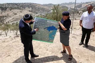 Bezalel Smotrich holds up a map showing the planned E1 settlement