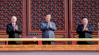 2025年9月3日，中國領導人習近平（中）在北京勝利日閱兵上，與俄羅斯總統普京（左）及朝鮮最高領導人金正恩（右）一同鼓掌。
