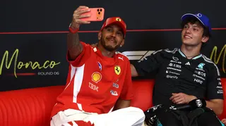 Lewis Hamilton takes a picture with race winner Kimi Antonelli in the post-race news conference