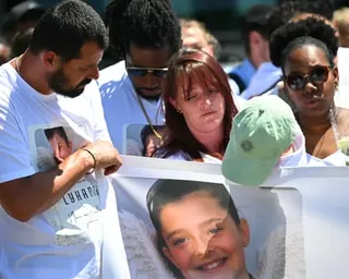 Lyhanna's parents and others carry a large banner with her photo