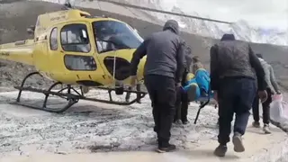 A man is being taken to a helicopter on a stetcher
