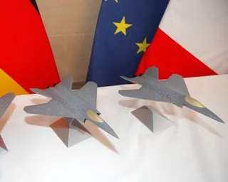 Two scale models of a fighter jet in front of the German, French and EU flags