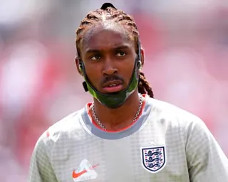 Djed Spence in an England training shirt wears a protective jaw brace