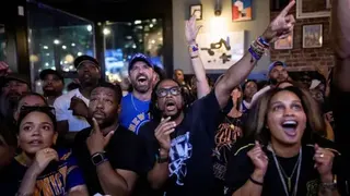 Getty Images A group of cheering fans wearing Knicks gear in a bar