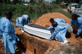 Volunteers of the Democratic Republic of Congo Red Cross prepare to bury the body of someone who died from Ebola in a cemetery in Ituri province