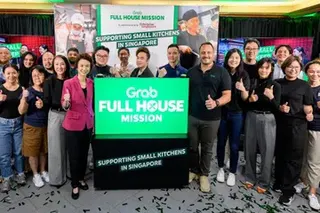 Senior Minister of State for Trade and Industry Low Yen Ling (in pink jacket) and Grab Singapore's managing director Alejandro Osorio (to the immediate right of the sign) at the launch of the “Grab Full House Mission” on Tuesday (Jun 9).