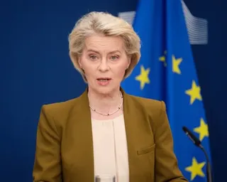 Ursula von der Leyen speaking in front of an EU flag
