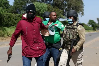 Police officers detain a demonstrator during a protest against a US-backed Ebola quarantine plan at a Kenyan airbase