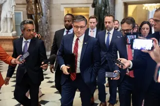a man walks while surrounded by people holding phones in his direction