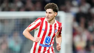 Julian Alvarez running in Atletico Madrid's red and white striped home shirt