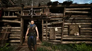 Gothic Remake Scatty's chest: A player stood outside Scatty's hut near the castle walls in the Old Camp, during the day, facing the camera.