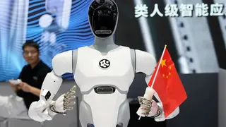 2025年8月8日，中國北京2025世界機器人大會首日，一台人形機器人手持中國國旗。（美聯社）