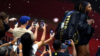Fans take photos of Serena Williams as she walks on court for the last time at the US Open in 2022