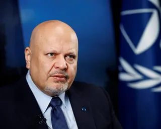 ICC Prosecutor Karim Khan in a dark suit and blue tie looks directly at the camera