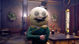 A man in a moon helmet stands in a room.