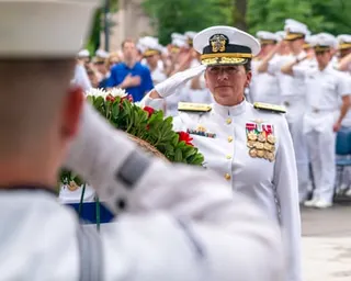 a woman in a white uniform salutes