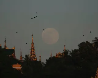 a supermoon rise over buildings