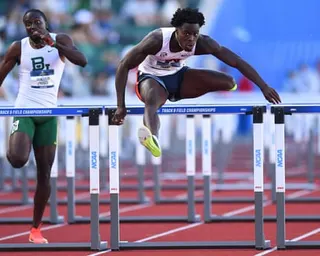 Ja'Kobe Tharp jumps a hurdle at the NCAA track and field championships.