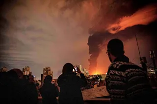 flames and smoke rise from an oil storage facility struck in Iran