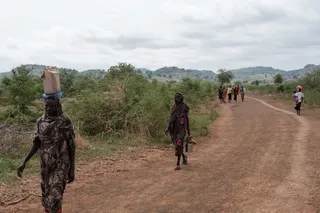 People walk along the road out of the Tiamushro camp for internally displaced persons (IDP) in South Kordofan state, Sudan on June 18, 2024.