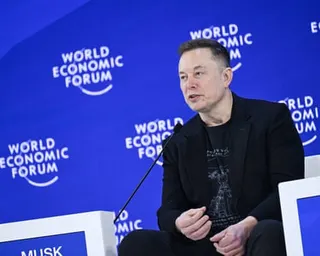 a man speaks while seated on stage