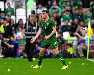 Séamus Coleman gestures to tennis balls thrown on to the pitch during the match against Qatar by fans protesting against Republic of Ireland's upcoming game with Israel.