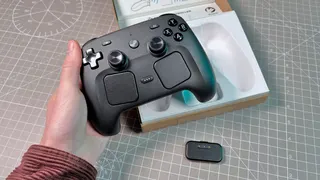 The Steam Controller on a desk during a teardown, with various parts removed.