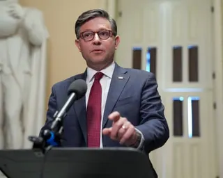 Man stands at lectern and speaks to reporters