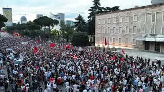 阿尔巴尼亚的抗议者周四在首都地拉那的总理府前示威，他们手持标语牌和国旗，抗议在靠近发罗拉市的兹维尔内茨自然保护区附近建造豪华度假村。（图取自法新社）