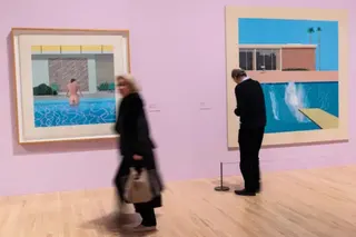Getty Images Visitors to 2017 Tate Britain exhibition look at 'Peter Getting Out of Nick's Pool', 1966 (L) and 'A Bigger Splash', 1976 (R)