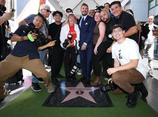 貝克漢(中)12日在洛杉磯好萊塢星光大道揭幕典禮後，與媒體人員合影。(路透)