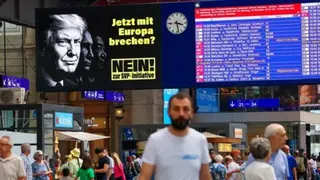 Reuters A poster shines out over a railway station as people walk underneath