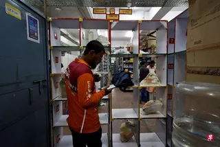 在印度首都新德里，一名平台配送员正在生鲜仓库领取订单上所列的食品杂货。 （路透社）