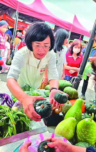 民進黨新北市長參選人蘇巧慧（左）昨天到淡水參加大南瓜比賽頒獎，也去逛攤位選購南瓜。記者林昭彰／攝影