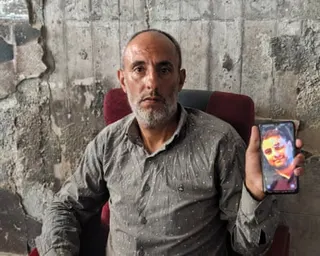 Al-Yazji holds up a picture of his brother on his phone