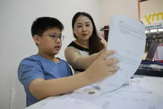 Primary 6 pupil Lucas Yee being reminded by his mother, Jessy Liu, to slow down and check his work.