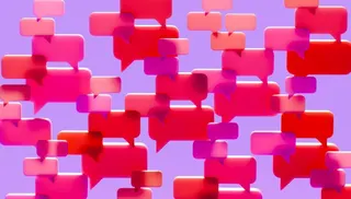 Conceptual image of a dense cluster of three-dimensional speech bubbles in shades of pink red and magenta overlapping and filling the visual field against a solid vibrant purple background.