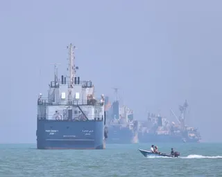 A small motorboat passes anchored vessels in the Strait of Hormuz off Bandar Abbas, Iran, Thursday, June 11, 2026.
