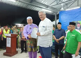 Lawyer Datuk Zaid Ibrahim hands over his PAS membership application form to PAS Deputy President Datuk Seri Tuan Ibrahim Tuan Man in Seremban last night. — NSTP/Mohd Amin Jalil.
