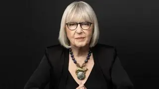Beowulf Sheehan A professional headshot of Harriet Newman Cohen, where she wears a black top, large statement necklace. Her hair is cut in a silver bob
