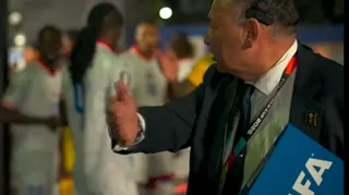 A Fifa official encourages Haiti players to assemble in the tunnel before their game against Scotland