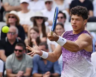 Ben Shelton returns the ball in a match against Taylor Fritz.