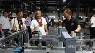 豐善印刷公司15日在八打雁省LIMA經濟特區，舉行新廠落成暨成立10週年慶典，圖為公司負責人引導駐菲代表周民淦（中）參觀廠房。中央社記者林行健LIMA經濟特區攝　115年6月15日