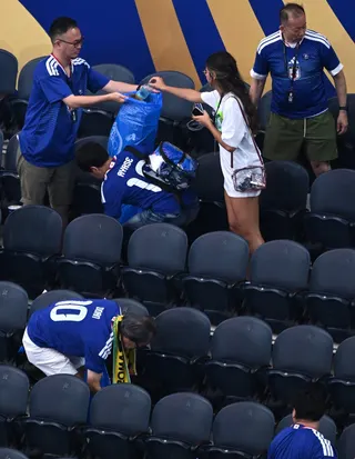 Japan fans clean up rubbish in the stadium following a World Cup match on Sunday. Photo: AP