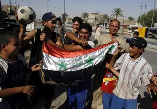 Men celebrate in Baghdad following Iraq’s 3-1 Asian Cup victory over Australia in July 2007.