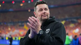 Pierre Sage, wearing a black hoodie while in charge of Lens, claps at the end of a game